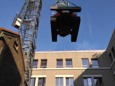 Takeuchi minigraver van GLK met torenkraan over gebouw zetten